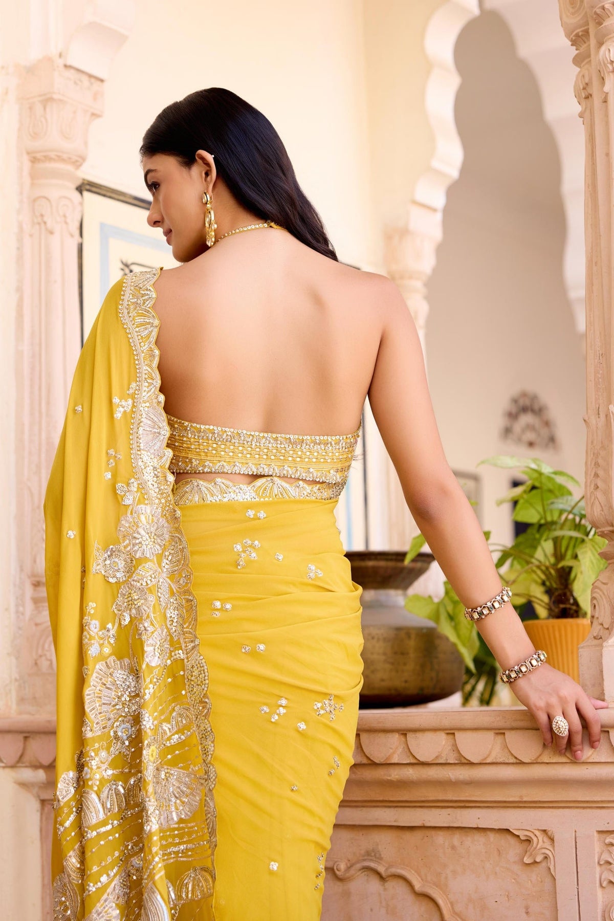 Canary yellow saree set with a back view showcasing the contemporary halter-style blouse design